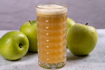 Apple juice. Freshly squeezed juice. Freshly squeezed apple juice in glass on stone background. Close-up
