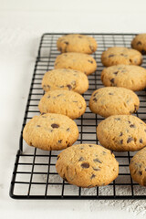 Oatmeal cookies with chocolate drops on the black cooling rack. White background