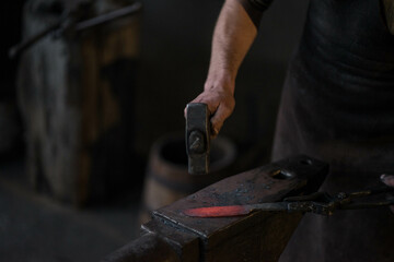 blacksmith hitting a red-hot iron with a hammer