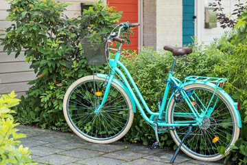 Fototapeta na wymiar Vintage Bike with Basket next to building. Classic retro bike with basket in Nature Outside. Close up. 