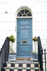 Bright beautiful wooden door with steps. Flowers near the wooden door.