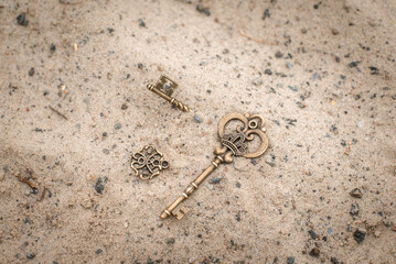 Ancient key in the sand. Lost vintage key. Golden treasure in the ground.