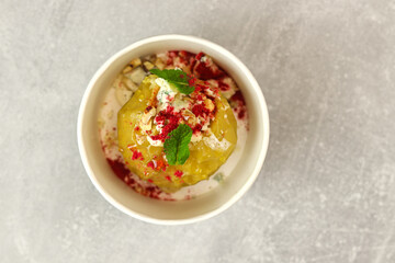 Baked apple with blue cheese, spices and nuts in a takeaway box  on a gray background. Healthy food delivery concept.