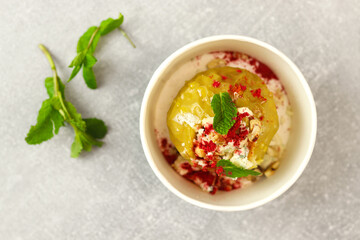 Baked apple with blue cheese, spices and nuts in a takeaway box  on a gray background. Healthy food delivery concept.