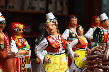 Albanian clay toys (figurines) of women and men in traditional oriental costumes. Culture, souvenirs. - obrazy, fototapety, plakaty