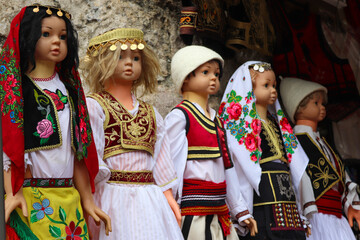 Ancient Albanian dolls (toys) in traditional costumes. Albania, souvenir shop, market, culture.