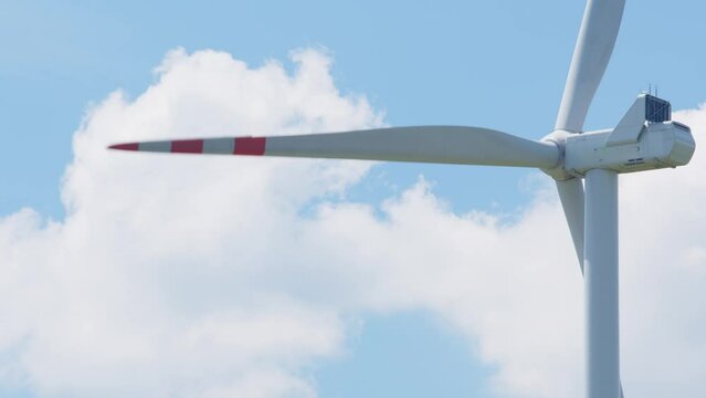 Widok z tyłu na kręący sie wiatrak zielonej energii odnawialnej