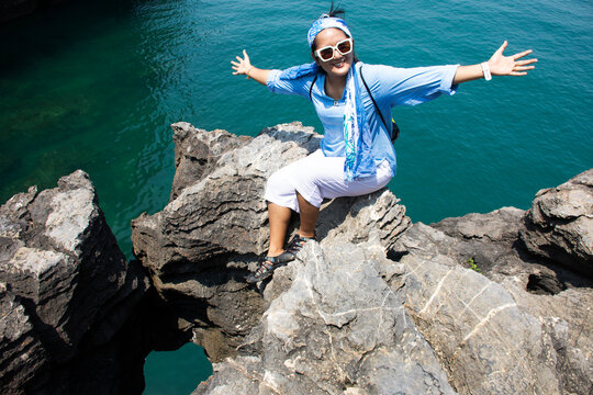 Travelers thai women people travel visit unseen trip at Ao Toa Ba beach and posing portrail take photo with stone sea ​​heart on cliff in ocean of Pak Bara waterfront at La ngu city of Satun, Thailand