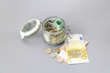 Us dollars and Euro banknotes in a glass jar. Bills and coins in a piggy bank. Save money. World Financial crisis.