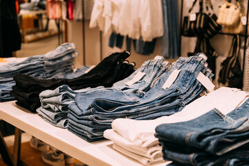 Stack Of Jeans On Shelves In Store Of Shopping Center. shelf display in shop mall store. Store Of Shopping Center. retail sale.