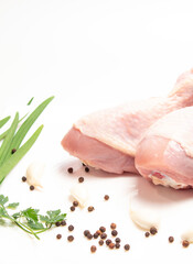 raw chicken legs in a plate on a white background