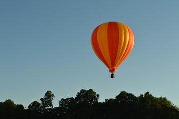 Bright orange and yellow hot air balloon flying in the sky