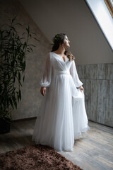 A lush, charming bride in the room. Stylish girl in a wedding dress with a bridal bouquet.