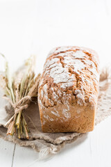 Bread on cloth with several grains and ears of wheat