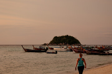 Women walking on the beach during sunrise. Summer vacation concept.