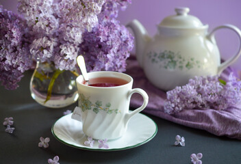Obraz na płótnie Canvas cup of tea with lilac flower