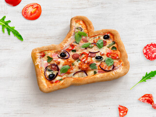 Mixture pizza with sausage and tomatoes in a shape of thumb up. Food art idea. pizza Like