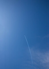 Blue sky with white clouds and a small plane left a trail place for text template