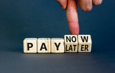 Pay later or now symbol. Businessman turns wooden cubes and changes concept words Pay later to Pay now. Beautiful grey table grey background. Business pay later or now concept. Copy space.