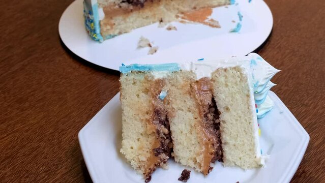 Closeup of a slice of vanilla cake with dulce de leche filling and crunchy walnuts_side tracking.