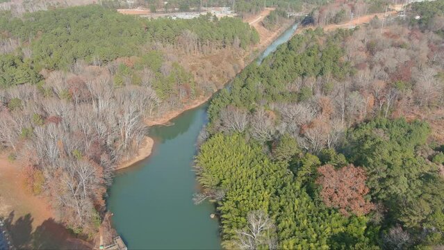  gorgeous aerial footage of the rippling waters of the Catawba River surrounded by lush green trees and autumn colored trees in Charlotte North Carolina USA