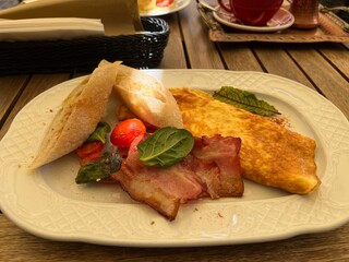 omelette with bacon and bread on a white plate