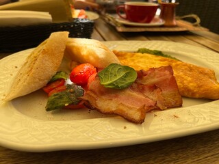 omelette with bacon and bread on a white plate