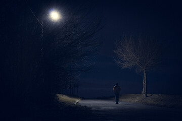 Sylwetka człowieka spacerującego nocą - obrazy, fototapety, plakaty