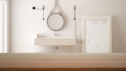 Empty wooden table, desk or shelf with blurred view of scandinavian white bathroom, washbasin with mirror and decors, modern interior design concept