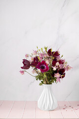 Vase with beautiful flowers bouquet on table against white background. Space for text