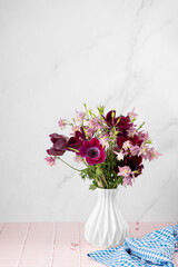 Vase with beautiful flowers bouquet on table against white background. Space for text