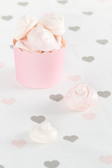 Small meringues in a pink package on a background with hearts. - 508820317
