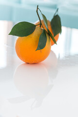 Fresh oranges on a white table, turquoise in the background. - 508820366