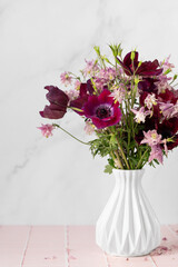 Vase with beautiful flowers bouquet on table against white background. Space for text