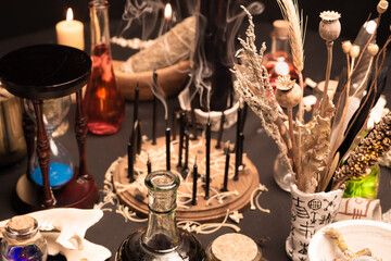 Witchcraft still life with witch weeds selective focus at front. Esoteric gothic and occult witch table for Halloween. Various magic objects and ritual arrangement with symbols. Gothic Halloween.