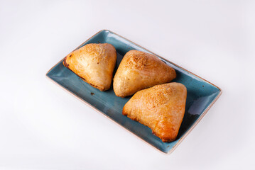 three samsa in a plate on a white background