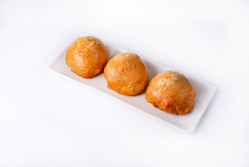three samsa in a white plate on a white background