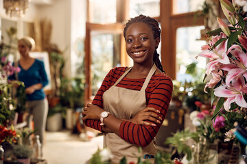 Confident black flower shop owner with her arms crossed looking at camera.