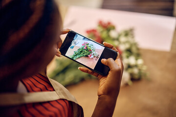 Close up of florist photographing flowers with cell phone at flower shop.