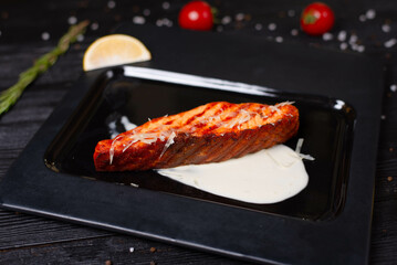 grilled salmon fish, with sauce and sprinkled with cheese