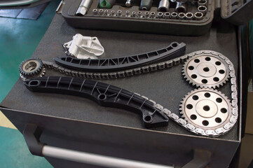A complete new timing chain replacement kit is laid out on a gray tool cart