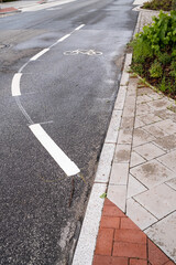 Obraz premium Signs on an asphalt road allowing cycling. Bike lane with symbols and dotted line. Concept of safe movement.