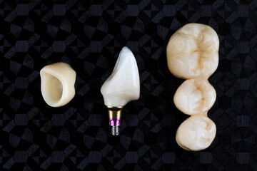 Composition Dental crowns from zircon and ceramics, removed from above on black textural background