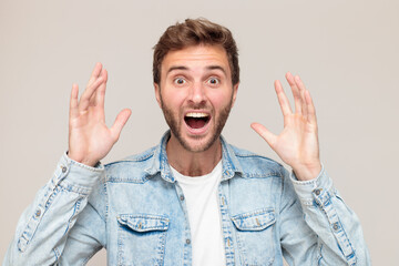 Young hipster male with stubble in a white t-shirt and light blue denim shirt. Emotion - a...