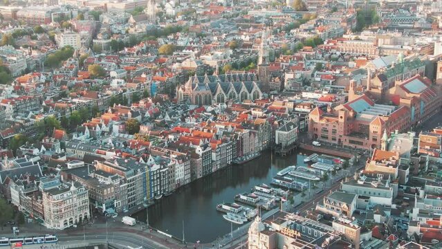 Aerial of the famous houses lining the edge of the Damrak canal basin, Amsterdam, Netherlands in the early morning