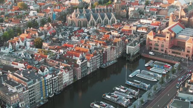 famous houses lining the edge of the Damrak canal basin, Amsterdam, Netherlands in the early morning