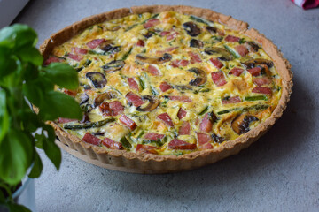 Quiche Lorraine Tart. Quiche is a tart consisting of pastry crust filled with eggs custard and pieces of cheese, bacon, and asparagus.