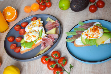Poached Benedict Egg on a slice of baguette with avocado and cherry tomatoes.