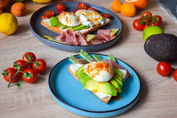 Poached Benedict Egg on a slice of baguette with avocado and cherry tomatoes.