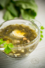 Spring soup from fresh sorrel with boiled eggs in a plate